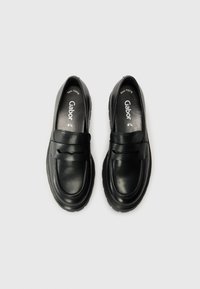 Black leather loafers with a rounded toe and thick rubber sole. Features a wide strap across the vamp and minimal stitching details.