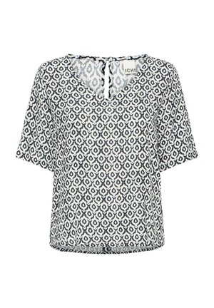 Kortermet V-hals bluse i lett stoff, med et geometrisk mønster i marineblått og hvitt, med en knappåpning bak.
