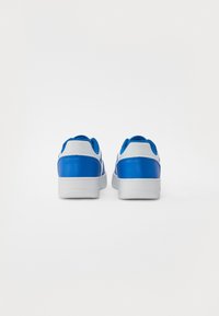 Blue and white sneakers with a smooth leather upper, rounded toe, and textured rubber sole. Features blue accents on the heel and tongue.