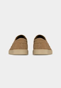 Paire de baskets en daim beige avec semelles en caoutchouc beige, vues de dos sur un fond uni gris clair.