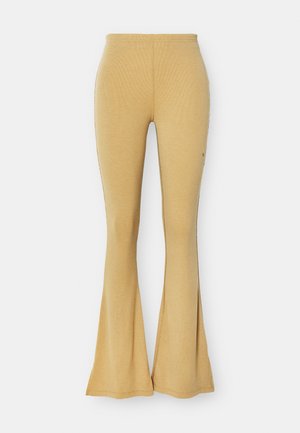 Geltoni megzti pločiau žemyn einantys kelnės su raukšlėta tekstūra, turinčios šoninius plyšius ir prigludusią taliją, užtikrinančią patogią siluetą.