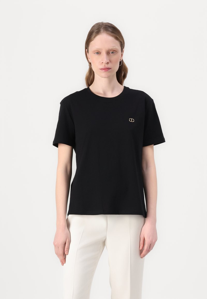Svart bomulls t-skjorte med rund hals, korte ermer og en liten gulllogo på brystet. Enkelt, rett-snittet design.