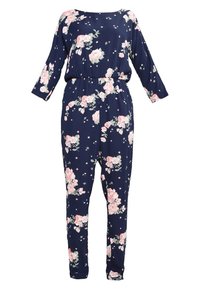 Combinaison bleu marine à manches longues avec imprimé floral rose et blanc, taille cintrée et jambes fuselées sur fond blanc.