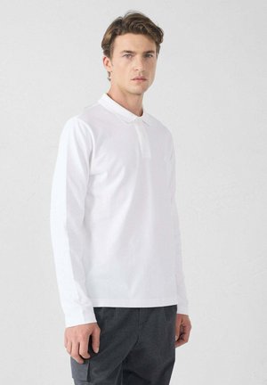 Camisa polo blanca de manga larga con cuello, hecha de algodón, que presenta un logo sutil en el pecho y un ajuste relajado.