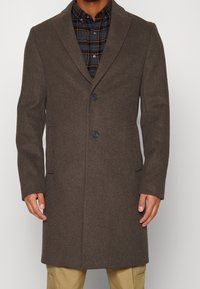 Cappotto di lana marrone con colletto a scialle, design monopetto, due tasche frontali e due bottoni, con una trama liscia.