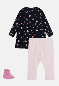 Kvetinové šaty v námořní modrej farbe s ružovými a zelenými akcentmi, skombinované s svetloružovými legínami a ružovou ponožkou. Bavlnená látka, dlhé rukávy, zberaný pás.