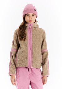 Bruine fleece jas met roze accenten, hoge kraag en ritssluiting. Gecombineerd met een roze gebreide beanie. Gladde textuur, ontspannen pasvorm.