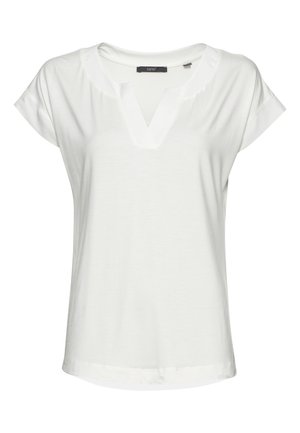 Blouse blanche pour femme à manches courtes, encolure en V et coupe ample, réalisée en tissu léger et lisse.