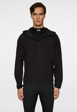 Giacca leggera nera con cappuccio e zip a un quarto, caratterizzata da un logo discreto sul petto e polsini elasticizzati. Tessuto morbido, design sportivo.