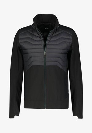 Czarna kurtka z zamkiem błyskawicznym, pikowanym przodem oraz gładką tkaniną o kontrastujących matowych i błyszczących fakturach. Ozdobiona niebieskim zamkiem.