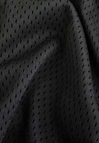 Tissu en maille noir présentant de petits trous régulièrement espacés pour favoriser la respirabilité. La texture est lisse avec une qualité légèrement élastique.