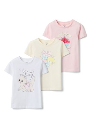 Trois t-shirts enfants à manches courtes en blanc, crème et rose avec des illustrations de chaton, macarons et bol de cerises, accompagnés de texte.