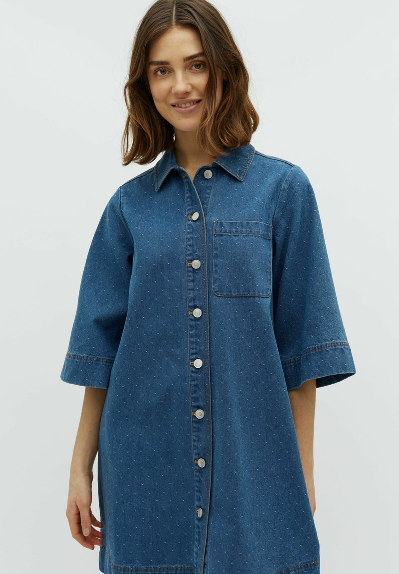 Denimhemdkleid in Dunkelblau mit kurzen Ärmeln, durchgehender Knopfleiste, Brusttasche und subtil strukturiertem Muster.