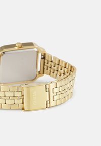 Goldener Metallarmbanduhr mit quadratischem Gehäuse, glatter Oberfläche und einem verlinkten Armband mit einem Verschluss, der den eingravierten Markennamen trägt.