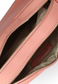 Borsa in pelle color pesca con finitura testurizzata, dotata di doppie cerniere e una fodera interna liscia in khaki.