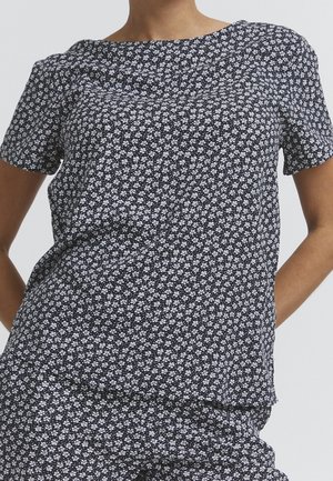 Korte mouwen top met bloemenpatroon in marineblauw met witte bloesems. Zachte stof met een iets losse pasvorm en ronde hals.