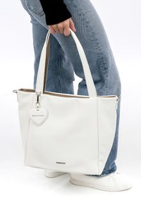 Bolso tote de cuero blanco con acabado texturizado, dos asas y un charm en forma de corazón etiquetado "EMILY&NOAH". Parte superior con cremallera y forro suave en el interior.