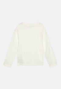Maglietta a maniche lunghe con collo rotondo in cotone avorio. Tessuto liscio con orli cuciti, senza fantasie né stampe. Design semplice e minimalista.