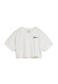 Camiseta corta blanca de algodón con manga corta, que presenta un logo de "Vans" bordado en el lado izquierdo del frente.