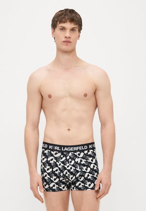 Juodi bokso šortai su monochrominiu dizainu, kuriame kartojasi animacinių veidų motyvas. Juosmuo pažymėtas „KARL LAGERFELD“ prekės ženklu. Minkštas audinio tekstūra.