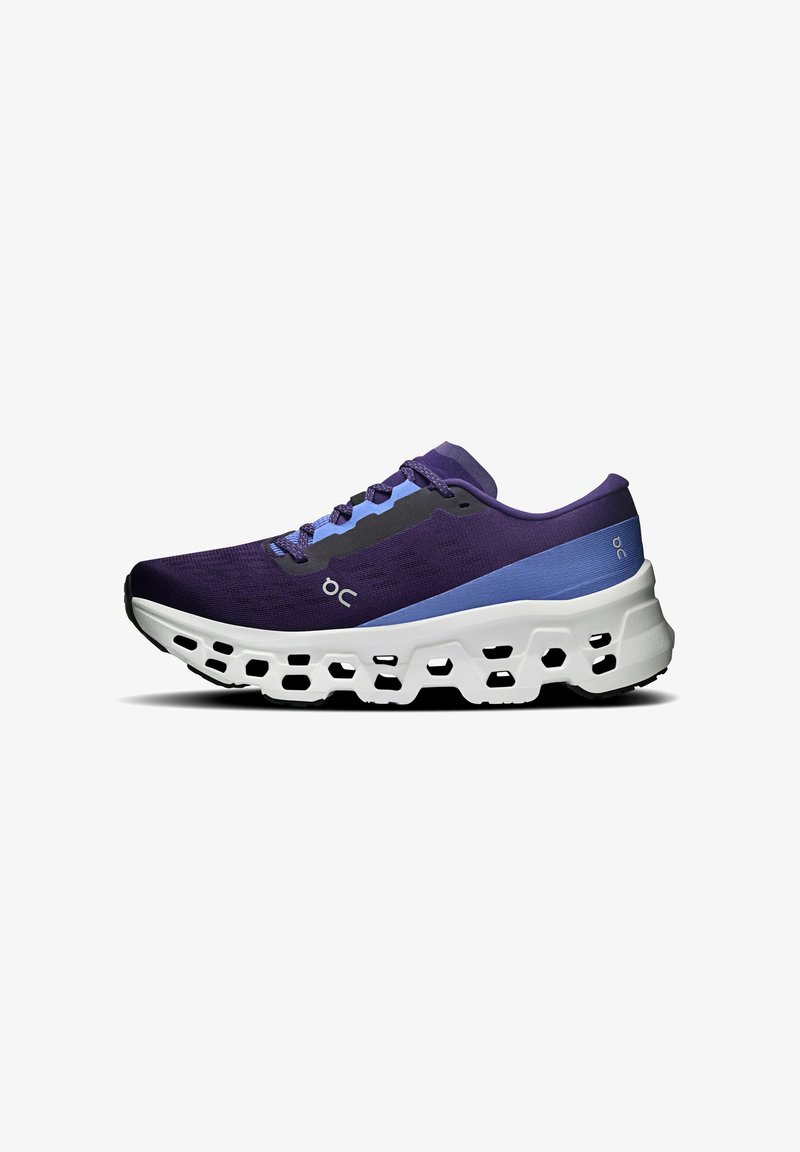 Chaussure de course violette et bleue avec une semelle épaisse blanche présentant des découpes hexagonales et une fermeture à lacets, vue de côté sur fond blanc.