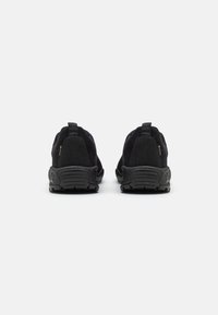 Pantofi sport negri cu un upper din material texturat, talpă din cauciuc și bucle de prindere la călcâi, concepuți pentru confort și funcționalitate.