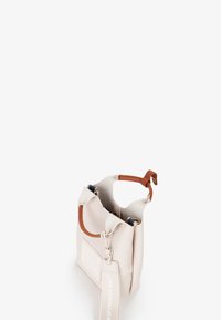 Piccolo handbag beige con manico in pelle marrone e tracolla staccabile etichettato "Borsa Responsabile", esposto aperto su sfondo bianco.