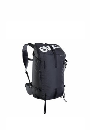 Sac à dos compact noir avec bretelles rembourrées, fermeture à boucle à l'avant, poche latérale zippée et logo "evoc" sur le rabat supérieur.