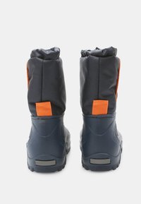 Nepremočljivi črni škornji z oranžnimi poudarki, ki imajo mehko podloženo zgornji del in fleksibilen gumijast podplat za oprijem in udobje.