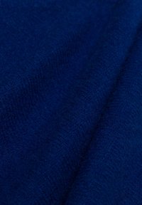 Tiefblaue Stoff mit einer strukturierten Oberfläche, der eine Mischung aus Fasern zeigt. Das Material wirkt weich und leicht flauschig, mit subtilen Variationen.