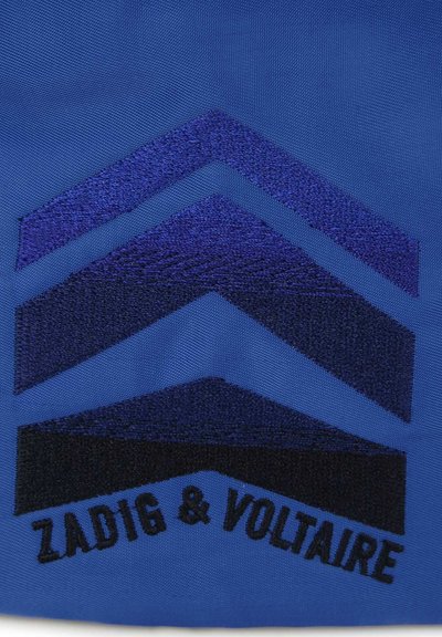 Blauwe stof met een geborduurde chevronontwerp in donkerblauw en zwart. De tekst "ZADIG & VOLTAIRE" is in zwart onderaan geborduurd.