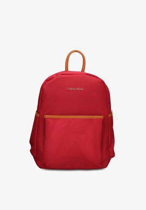 Zaino rosso con manico e rifiniture marroni, tasca frontale con zip e logo del marchio dorato sul pannello frontale superiore su sfondo bianco.