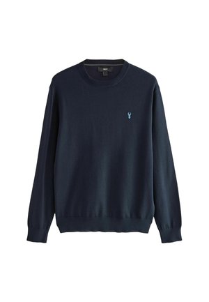 Sötétkék kötött pulóver kerek nyakkivágással és hosszú ujjal. A bal mellen egy kis világoskék logó található. Puha textúra.