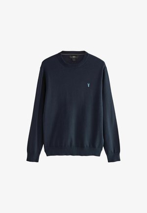 Sötétkék kötött pulóver kerek nyakkivágással és hosszú ujjal. A bal mellen egy kis világoskék logó található. Puha textúra.