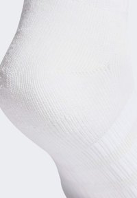 Calcetín de algodón blanco con textura acanalada, que presenta una zona lisa y sin costuras alrededor del tobillo para mayor comodidad y flexibilidad.