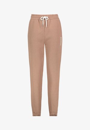 Beige Jogginghose aus weichem Material, mit einem Kordelzugbund, schmal zulaufenden Beinen und weißem Textdetail an der Seite.