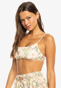 Top de bikini floral con suaves patrones en rosa y verde. Fabricado en una tela elástica con finas tiras ajustables y un diseño sin costuras.
