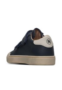 Námořnické kožené boty s krémovým podpatkem, texturovanou podrážkou a třepenými denimovými akcenty na tkaničkách. Na zadní straně se nachází kruhové logo.