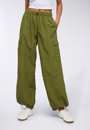 Pantaloni cargo verdi realizzati in tessuto leggero, dotati di polsini elasticizzati, numerose tasche e una vestibilità comoda con vita regolabile tramite coulisse.