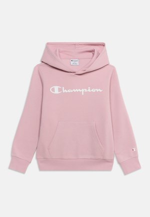 Jasnoróżowa bluza Champion z kapturem, przednią kieszenią kangurka, kapturem oraz białym logo Champion na piersi i małym logo na mankiecie lewego rękawa.