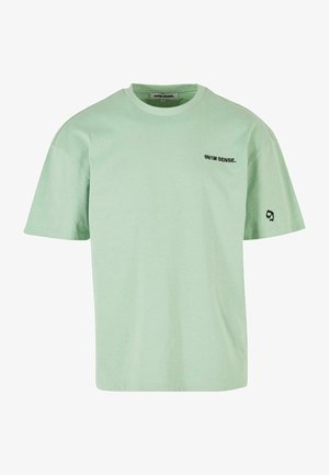 Mentazöld, rövid ujjú pamut póló. Kerek nyakú, a elején egy kis fekete logóval és további részletekkel az ujján.