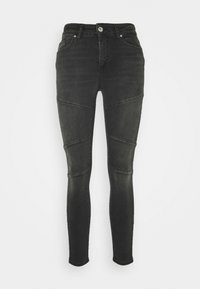 Vaqueros skinny de mezclilla negra con cintura alta, que presentan detalles en panel y costuras en contraste, textura suave y diseño estándar de cinco bolsillos.