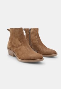 Botine din suede maro, cu fermoar lateral, textură netedă, vârf în formă de migdală și toc scăzut. 