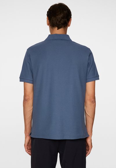 Heren polo met korte mouwen in donkerblauw, voorzien van een klassieke kraag, een gladde textuur en een rechte zoom met zijventilatie.