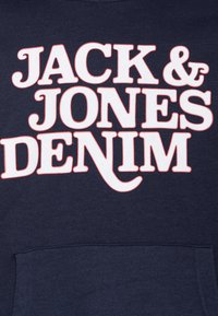 Felpa con cappuccio blu navy con grande testo bianco e rosso: "JACK & JONES DENIM." Presenta una tasca frontale e una texture di tessuto morbido.