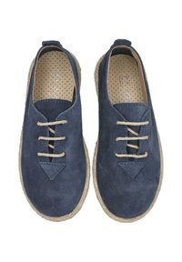 Zapatos de ante azul con suelas de yute crema, que presentan un diseño de cordones y un detalle triangular en la parte delantera. Forro interior texturizado con lunares.