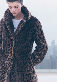 Leopardprintfrakke i blødt, tekstureret stof med bred krave, lange ærmer og to forlommer. Subtle knapdetalje.