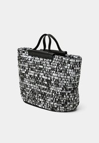 Sac fourre-tout tissé en noir et blanc avec une finition texturée. Comprend des poignées supérieures doubles et une forme rectangulaire plate.