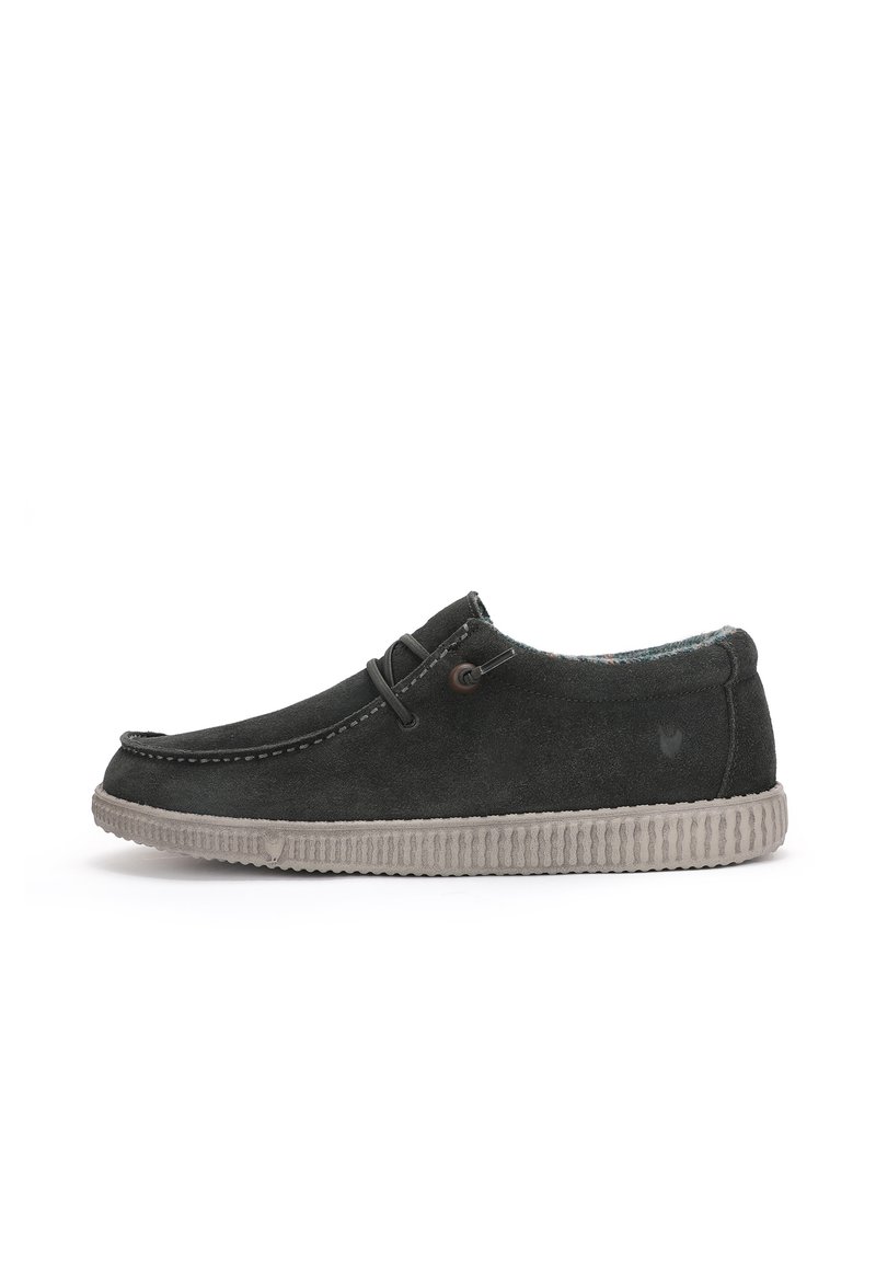 Chaussure à enfiler en suède gris foncé avec semelle en caoutchouc gris clair, présentant des coutures décoratives et deux œillets avec des lacets pour le réglage.