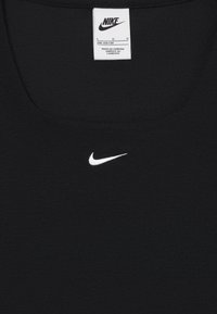 Čierny tank top Nike s ryhovanou textúrou, na prednej strane s bielym logom Nike, okrúhlym výstrihom a priloženou starostlivosťou.